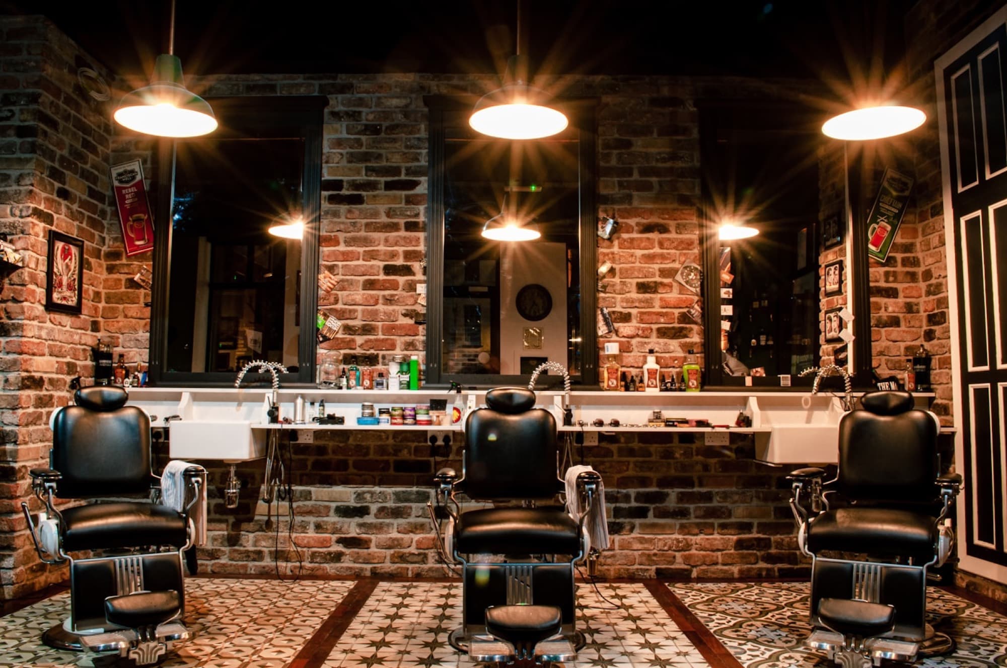 The interior of a classic barbershop with leather chairs and warm pendant lighting
